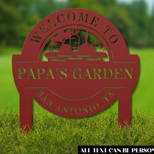 K&ouml;nnte beinhalten: Rotes Metall-Gartenschild mit einem Willkommen im Garten von Papa-Design. Das Schild zeigt einen Korb mit Gem&uuml;se und den Text San Antonio, TX. Der gesamte Text kann personalisiert werden.