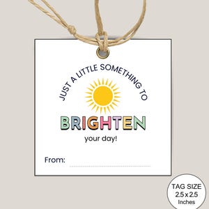 May include: A white gift tag with the text "JUST A LITTLE SOMETHING TO BRIGHTEN your day!" and a yellow sun graphic. The tag is square, measuring 6.35 x 6.35 cm, and is attached with twine.