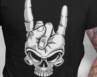 May include: A black t-shirt featuring a white graphic of a skull with a hand making the rock and roll hand gesture.