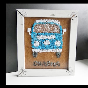 May include: A framed mosaic artwork depicting a blue and white van with the word "Dharma" written below it.