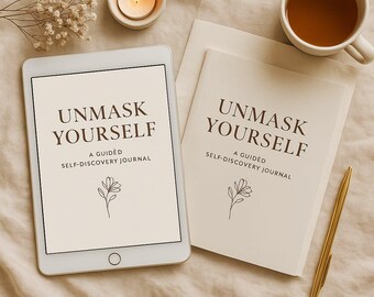 May include: An off-white tablet and journal with the text "UNMASK YOURSELF" and "A GUIDED SELF-DISCOVERY JOURNAL". A lit candle, a cup of tea, a gold pen, and dried flowers are also present. The journal and tablet have a floral design.