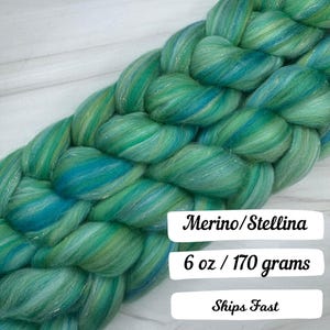Pode incluir: Roving tran&ccedil;ado de fibra Merino/Stellina em tons de verde-azulado, verde e azul. A fibra pesa 170 gramas. A fibra &eacute; macia e brilhante, perfeita para fiar ou feltrar.