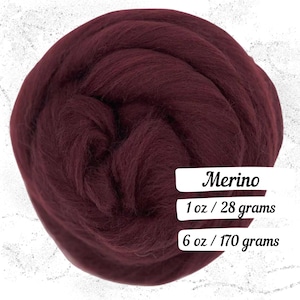 May include: A close-up of a ball of burgundy Merino wool. The image shows the texture and color of the wool, with text indicating the weight: 1 oz / 28 grams and 6 oz / 170 grams.