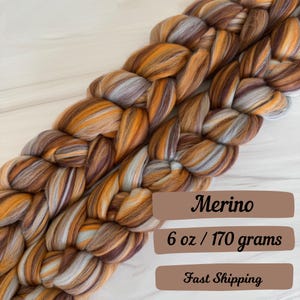 May include: A braid of brown, orange, and white merino wool roving. The roving is 6 ounces or 170 grams. The text "Merino", "6 oz / 170 grams", and "Fast Shipping" is visible on the image.