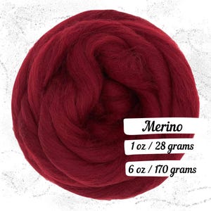 May include: A large, round ball of deep red Merino wool roving. The image includes text that reads "Merino", "1 oz / 28 grams", and "6 oz / 170 grams". This wool is likely used for fiber art projects.