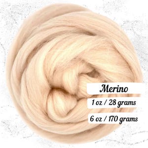 May include: A close-up of a light beige Merino wool roving. The image includes text that reads "Merino", "1 oz / 28 grams", and "6 oz / 170 grams". The wool is tightly packed and appears soft and fluffy.