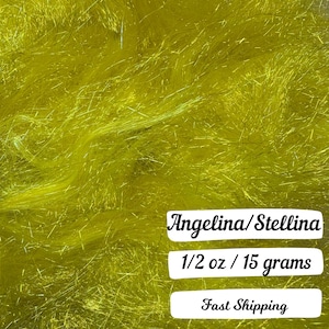 May include: Close-up of a pile of bright yellow Angelina/Stellina fiber. The text on the image reads "Angelina/Stellina" and "1/2 oz / 15 grams". The fiber has a shimmering, metallic appearance.