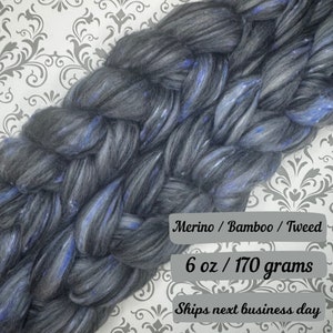 May include: A skein of black, blue, and grey merino wool yarn with a tweed texture. The yarn is 6 ounces or 170 grams. Merino / Bamboo / Tweed. Ships next business day.