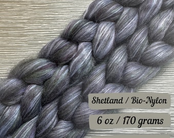May include: A braid of dark gray Shetland wool yarn with a subtle green and white stripe, blended with bio-nylon. The yarn is 6 ounces or 170 grams. Shetland / Bio-Nylon 6 oz / 170 grams Ships next business day