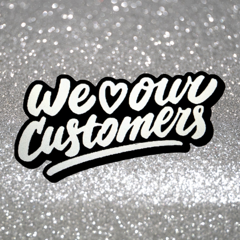 May include: White text on a black background with a heart symbol reads "We &hearts; our customers" against a silver glitter background.