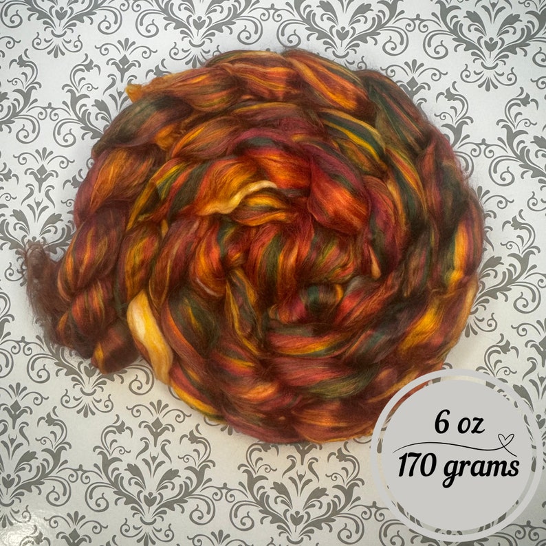 May include: A ball of colourful yarn in shades of red, orange, yellow, and green. The yarn is 6 oz or 170 grams.