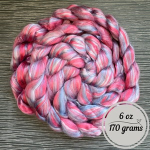 Pode incluir: Um pacote de 170 gramas de l&atilde; merino rosa, branca e azul.