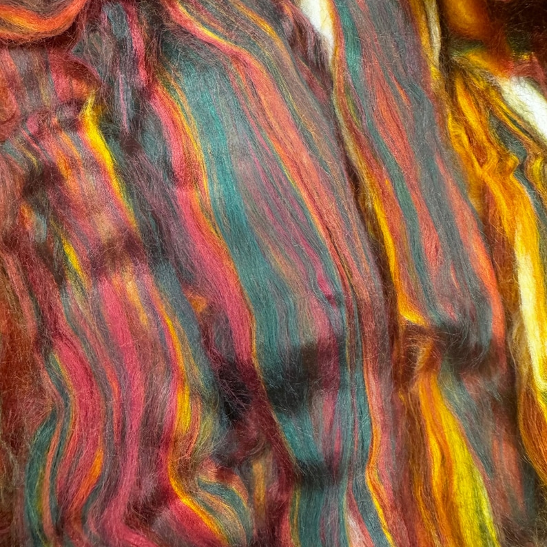 May include: A close-up of a colourful yarn with streaks of red, orange, yellow, green, and brown.