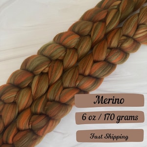 May include: Two strands of orange, green, and brown merino wool roving, braided together. The roving is 6 ounces or 170 grams.