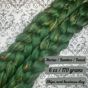 May include: A braid of green, gold, and red merino wool, bamboo, and tweed yarn. 6 oz / 170 grams. Merino / Bamboo / Tweed.