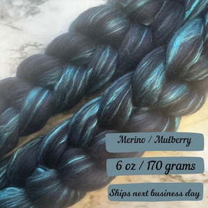 May include: Black and teal merino wool yarn with a striped pattern. 6 oz / 170 grams. Ships next business day.