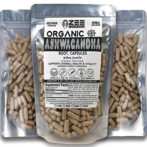 May include: Three silver pouches containing brown capsules labeled "Organic Ashwagandha Root, Capsules" with the brand name "Zee Herbs" and the text "Nature's key to resilience and balance!"  The pouches are labeled with the text "Vegetarian Capsules" and "Herbal Supplement".