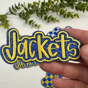 May include: A blue and yellow embroidered patch with the word "Jackets" in a bold, cursive font.