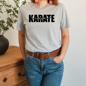 May include: A gray t-shirt with the text "KARATE MOM" printed in black.