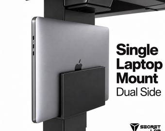 May include: A black metal laptop mount attached to a desk leg, holding a silver laptop. The text reads: Single Laptop Mount Dual Side, Secret Lab, Render not 100%. The mount features a vertical bracket design to secure the device to the desk frame.