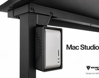 May include: A black metal mounting bracket attached to the underside of a desk, holding a silver Mac Studio computer. The bracket features a perforated side panel for ventilation. The text Mac Studio and the Secretlab logo are visible.