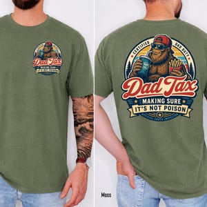 May include: Moss green t-shirt with a Bigfoot graphic. The graphic reads "Dad Tax" with the text "Making Sure It's Not Poison." The back of the shirt has a larger graphic with the text "Certified Dad Duty" and "Official Snack Inspector."