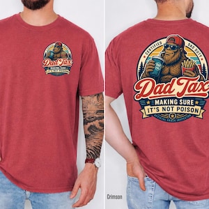 Puede incluir: Camiseta roja carmes&iacute; con un gr&aacute;fico de Bigfoot en la parte delantera y trasera. El gr&aacute;fico frontal dice "Dad Tax". El gr&aacute;fico trasero dice "Dad Tax" con Bigfoot sosteniendo una bebida y papas fritas. El texto dice "Making Sure It's Not Poison."