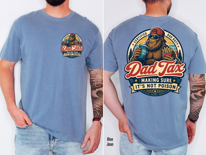 Puede incluir: Camiseta azul claro con un dise&ntilde;o de dibujos animados de Bigfoot. La parte delantera muestra un peque&ntilde;o gr&aacute;fico con el texto "Dad Tax". La parte trasera muestra un gr&aacute;fico m&aacute;s grande de Bigfoot con las palabras "Dad Tax, Making Sure It's Not Poison".