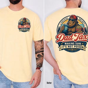 Puede incluir: Camiseta de color mantequilla con un gr&aacute;fico de Bigfoot. El gr&aacute;fico frontal dice "Dad Tax" con el texto "Making Sure It's Not Poison". El gr&aacute;fico trasero presenta a Bigfoot sosteniendo una bebida y papas fritas, con el texto "Certified Dad Duty".
