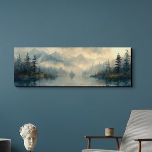 Może przedstawiać: Panoramiczny obraz krajobrazu przedstawiający mglisty jezioro otoczone drzewami i górami. Obraz jest oprawiony i wisi na niebieskiej ścianie nad brązowym drewnianym stolikiem i szarym fotelem.