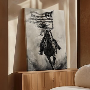 Könnte beinhalten: Ein Schwarzweißbild einer Frau, die ein Pferd reitet und eine amerikanische Flagge hält. Das Bild ist gerahmt und hängt an einer Wand in einem modernen Wohnzimmer.