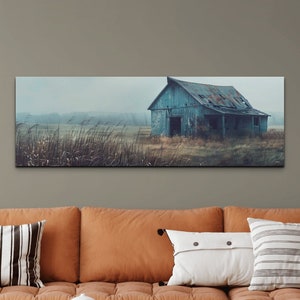 May include: A panoramic photograph of a weathered blue barn in a field with tall grass. The barn has a partially collapsed roof and is surrounded by a misty, atmospheric landscape.