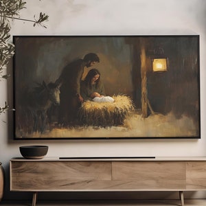 Könnte beinhalten: Ein Gemälde, das die Weihnachtsgeschichte mit Maria, Josef und dem Jesuskind in einem Stall darstellt. Das Gemälde ist gerahmt und hängt an einer Wand in einem Raum mit einem Schrank aus Holz und einer Topfpflanze.