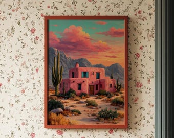 May include: A framed landscape painting depicts a pink adobe building with a desert scene under a sunset sky. The artwork is displayed on a floral wallpapered wall, above a white radiator and next to a teal door.