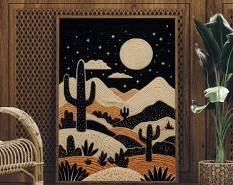 May include: A framed desert landscape art print featuring a black night sky with stars and a full moon. The artwork depicts cacti, mountains, and desert plants in shades of black, tan, and orange. The print is displayed in a wooden frame.