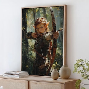 May include: A framed canvas painting of a woman with pointed ears, wearing a brown leather outfit and holding a bow and arrow. She is standing in a forest setting with green trees and foliage.