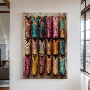 May include: A framed artwork featuring a collection of colorful cowboy boots. The boots are arranged in rows, showcasing a variety of floral patterns and vibrant hues, including pink, turquoise, and yellow. The artwork is displayed on a white wall.