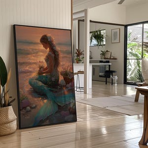 May include: A framed art print depicts a mermaid on a beach at sunset. The mermaid has long hair and a turquoise tail, holding flowers. Seashells and a basket of flowers are nearby. The artwork is in a black frame.