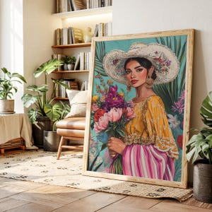 May include: A framed art print depicting a woman in a yellow blouse and pink striped skirt, holding a bouquet of flowers. She wears a large white hat with floral accents and gold earrings. The background is teal with tropical foliage.