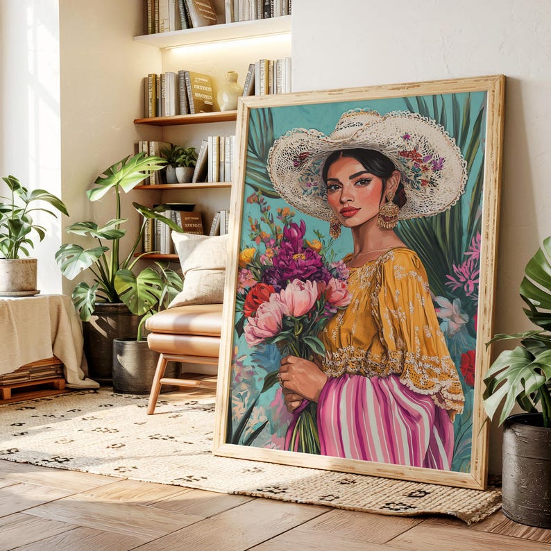 May include: A framed art print depicting a woman in a yellow blouse and pink striped skirt, holding a bouquet of flowers. She wears a large white hat with floral accents and gold earrings. The background is teal with tropical foliage.
