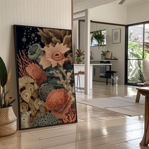 May include: A framed art print featuring a detailed illustration of coral and sea life in shades of peach, blue, and beige. The artwork includes various coral formations, sea anemones, and other marine elements against a dark background.