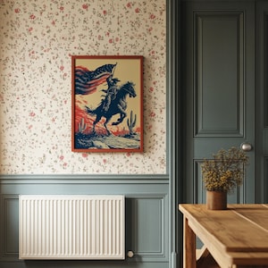 Könnte beinhalten: Ein gerahmter Druck zeigt einen Cowboy auf einem Pferd mit einer amerikanischen Flagge, vor einer Wüstenlandschaft mit Kakteen. Das Kunstwerk verwendet Rot, Weiß und Blau, mit einem braunen Rahmen.