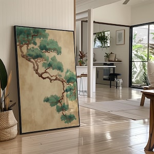 Könnte beinhalten: Ein gerahmter Kunstdruck mit einer stilisierten Darstellung eines Bonsai-Astes mit grünen Blättern und einem braunen Stamm. Das Kunstwerk ist vor einem beigen Hintergrund platziert und schwarz gerahmt. Der Druck lehnt an einer Wand in einem hellen Raum.