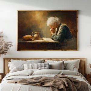 May include: A framed painting depicts an elderly person with white hair, hands clasped in prayer over an open book. A loaf of bread and a pitcher sit on the table. The artwork is set in a warm, dimly lit room, evoking a sense of peace and reflection.