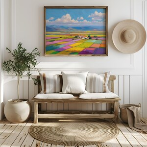 May include: A framed landscape painting shows a colourful field divided into squares, under a blue sky with clouds. A wooden bench with cushions, a potted plant, and a woven rug are also visible.