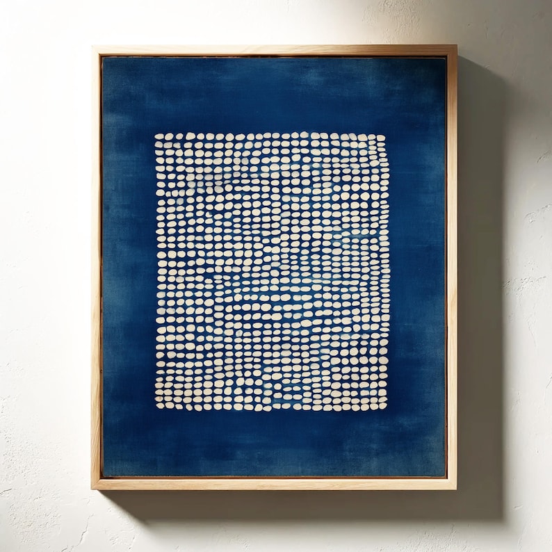 May include: Abstract art print in a natural wood frame. The artwork features a dark blue background with a square of white dots. The dots are arranged in a grid-like pattern. The frame is a light brown color.