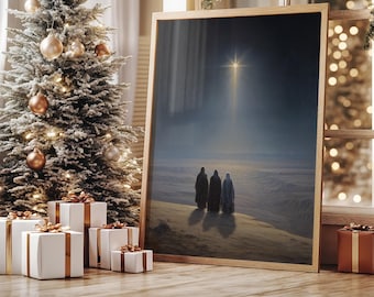 May include: A framed print depicting three figures in dark robes walking towards a bright star in a desert landscape. The print is displayed next to a decorated Christmas tree and wrapped gifts, creating a festive holiday scene.