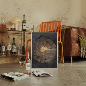 May include: A framed abstract art print featuring a detailed cross-section of a tree trunk, showcasing concentric rings in shades of brown and gold against a dark background. The print is displayed in a room with a bar cart, a leather sofa, and an orange chair.