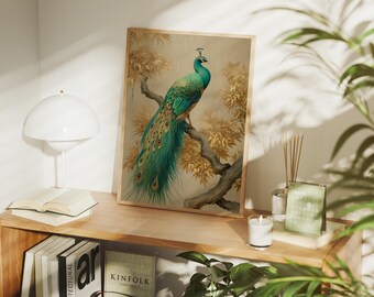 Puede incluir: Una impresión artística enmarcada con un pavo real posado en una rama. El pavo real tiene un plumaje turquesa y dorado vibrante, sobre un fondo de follaje dorado. La obra de arte se exhibe en una estantería de madera con libros y una lámpara.