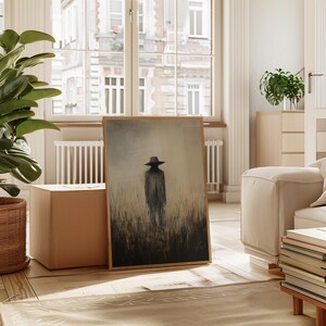 Peut inclure: Une impression d'art encadr&eacute;e repr&eacute;sentant une silhouette dans un champ. L'&oelig;uvre utilise des tons sourds de marron, gris et beige, avec un accent sur la silhouette. L'impression est pr&eacute;sent&eacute;e dans un cadre en bois clair, id&eacute;ale pour la d&eacute;coration int&eacute;rieure.
